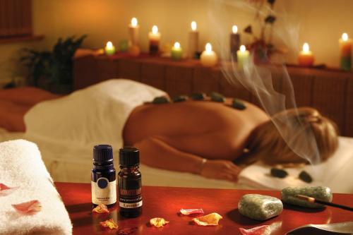 a woman is laying on a bed with candles at Egnatia City Hotel & Spa in Kavala