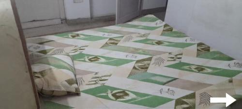 a room with a green and white tiled floor at Cozy Homestay in Prayagraj