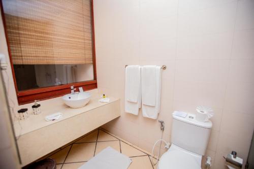 a bathroom with a toilet and a sink and a mirror at The Long Beach Resort & Spa in Koggala