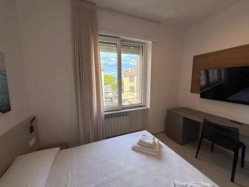 a bedroom with a bed and a desk and a window at MONTELLA B&b in Gaeta