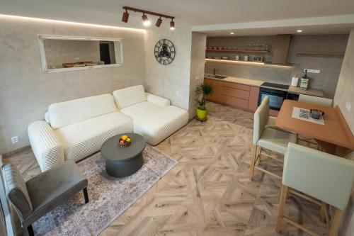 a living room with a white couch and a kitchen at Adela apartment in Košice
