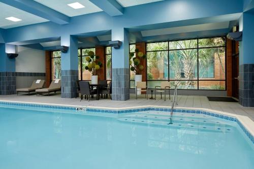 a pool in a hotel room with chairs and a table at Marriott DFW Airport South in Fort Worth