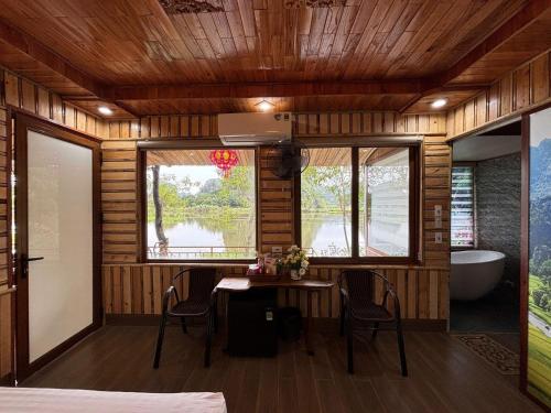 a room with a table and chairs and a bath tub at Xuan Son Lakeside Bungalow in Ninh Binh