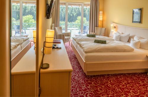 a hotel room with two beds and a living room at Waldhaus am See inklusive MeineCardPlus in Willingen