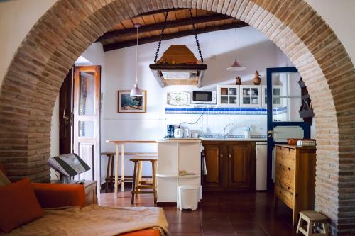 an archway in a kitchen with a table and a counter at Jardim de Vénus in Vila de Frades