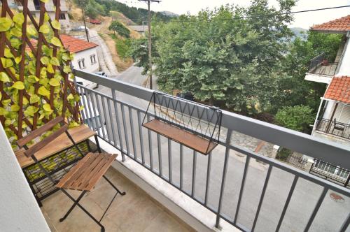 a balcony with a wooden chair and a railing at Casa Kleisoura in Klisoúra