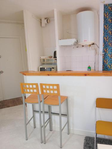 een keuken met twee stoelen aan een aanrecht bij TPSA20- ROOM Bis in Parijs