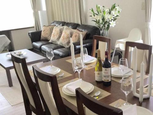 a dining room table with wine glasses and a couch at Second house TOYA / Vacation STAY 291 in Lake Toya