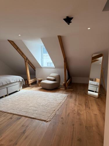 a attic bedroom with a bed and a mirror at Historische bovenwoning Wyck in Maastricht