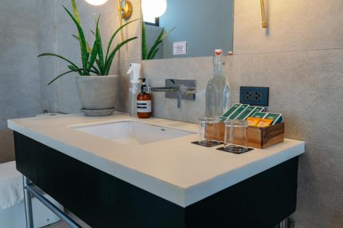 a bathroom counter with a sink and a bottle of wine at Nacpan Beach Resort Managed by H Hospitality Group in El Nido