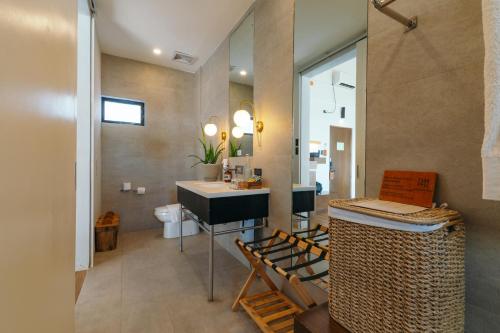 a bathroom with a sink and a toilet in it at Nacpan Beach Resort Managed by H Hospitality Group in El Nido