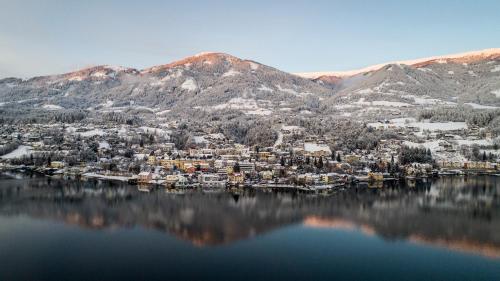 a city on a lake with mountains in the background at 1Schönes Ferienhaus im sonnigen Kärnten in Döbriach