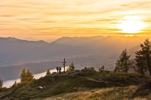 a man standing on top of a hill with a cross at 1Schönes Ferienhaus im sonnigen Kärnten in Döbriach