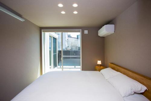 a bedroom with a large bed and a large window at Rakuten STAY HOUSE x WILL STYLE Matsue 101 in Matsue