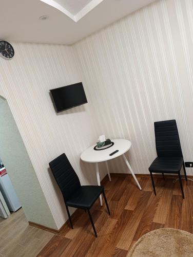 une pièce avec une table et deux chaises et une télévision dans l'établissement Zdanevuch, à Rivne