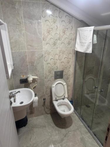 a bathroom with a toilet and a sink and a shower at New Safir Beach in Marmaraereglisi