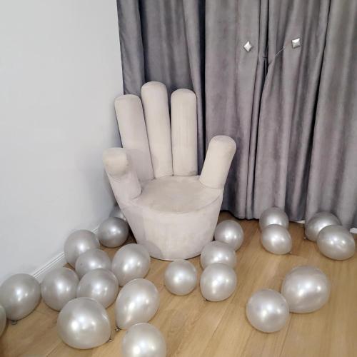 a bunch of white balloons on the floor next to a hand at Hotel Capital Inn Tirana in Tirana