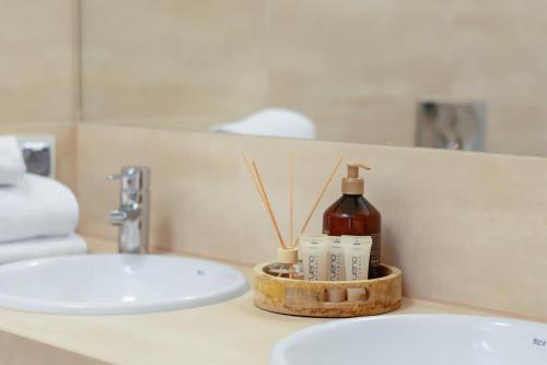 a bathroom sink with a bottle of soap and toothbrushes at AS HOME Apartamenty - Grand Designer Loft 90m2 RYNEK 505 in Wrocław