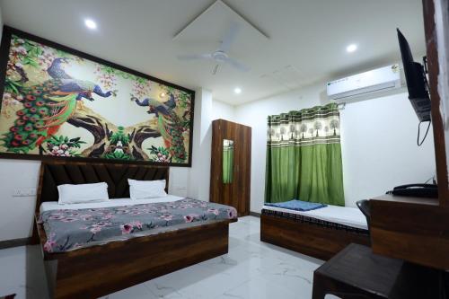 a bedroom with a bed and a tv and a window at Shri Girraj Residency in Mathura