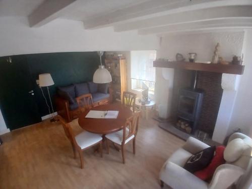 a living room with a table and a fireplace at La colline de Tara in Andelaroche
