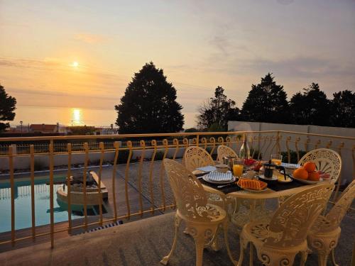 a table and chairs on a balcony with a meal on it at CASTRUM HOUSES - Nature Moledo - Jacuzzi - Sauna - Banho Turc - Bilhar - Matraquilhos in Moledo