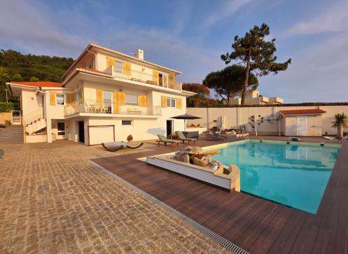 a villa with a swimming pool in front of a house at CASTRUM HOUSES - Nature Moledo - Jacuzzi - Sauna - Banho Turc - Bilhar - Matraquilhos in Moledo