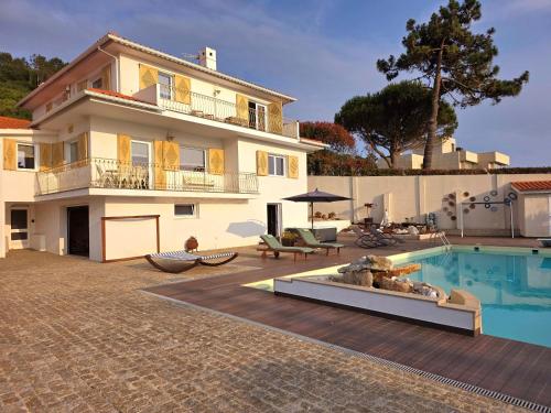 a villa with a swimming pool and a house at CASTRUM HOUSES - Nature Moledo - Jacuzzi - Sauna - Banho Turc - Bilhar - Matraquilhos in Moledo