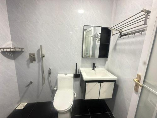 a bathroom with a white toilet and a sink at Violetfehi Homestay in Fuvahmulah