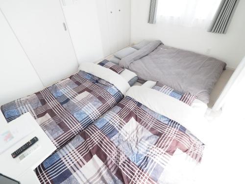 a bed in a room with two twin beds at La Lumiere Oroku / Vacation STAY 1068 in Naha