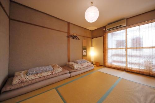 ein Zimmer mit zwei Betten in einem Zimmer mit Fenster in der Unterkunft Kyoto - House / Vacation STAY 69365 in Kyoto