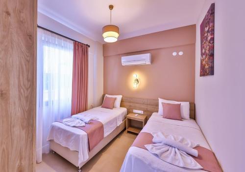カシュにあるVilla Kakuleのベッドが2つと窓があるホテルの部屋