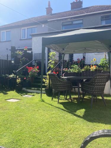 a table and chairs under an umbrella in a yard at North Coast Retreat in Portstewart