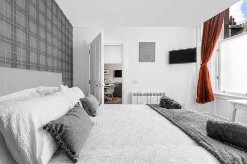 a bedroom with a large white bed and a desk at Castle Street Apartments - Luxury Kerrycroy Ground Floor Apartment in Rothesay