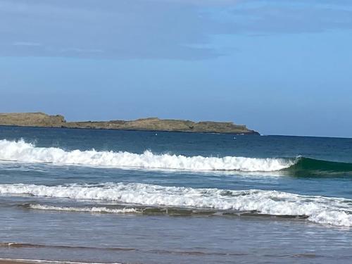 a group of waves in the ocean on a beach at North Coast Retreat in Portstewart