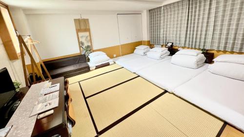 a hotel room with three beds and a desk at Reina Building 4F / Vacation STAY 40669 in Tokushima