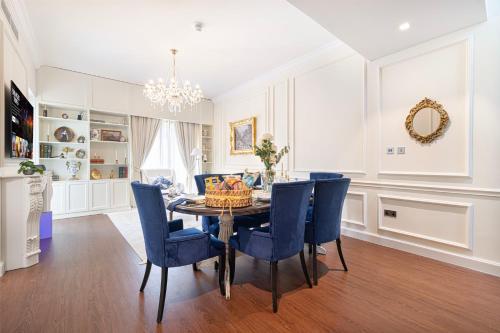 a dining room with a table and blue chairs at Abu Dhabi 4BR Villa - Victorian-Inspired Stay in Abu Dhabi