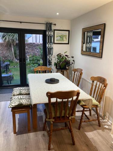 a dining room with a table and chairs and a window at North Coast Retreat in Portstewart