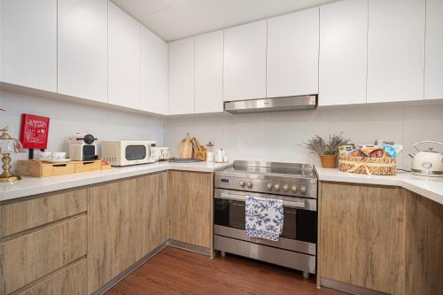 a kitchen with white cabinets and a stove top oven at Abu Dhabi 4BR Villa - Victorian-Inspired Stay in Abu Dhabi