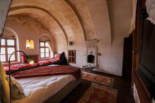 1 dormitorio con 1 cama en una habitación con un arco en Katre Cave House, en Ürgüp