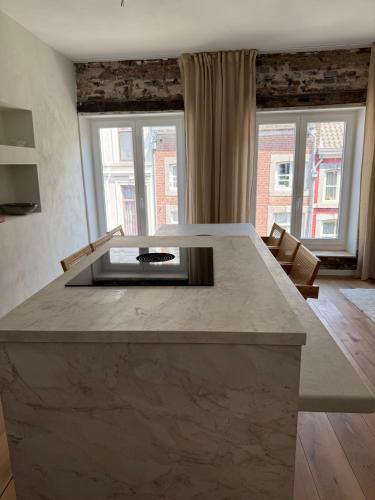 a kitchen with a large island in a room with windows at Historische bovenwoning Wyck in Maastricht