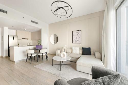 a living room and kitchen with a couch and a table at Silkhaus Close to Ferrari World Abu Dhabi in Al Qurayyah