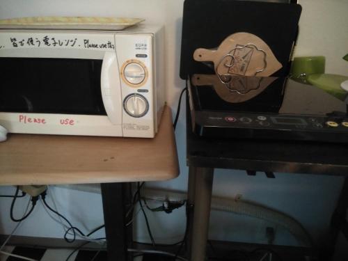 eine Mikrowelle auf einem Tisch neben einem Herd in der Unterkunft furorai KANAMATI Floral Kanamachi - Vacation STAY 12219 in Tokio