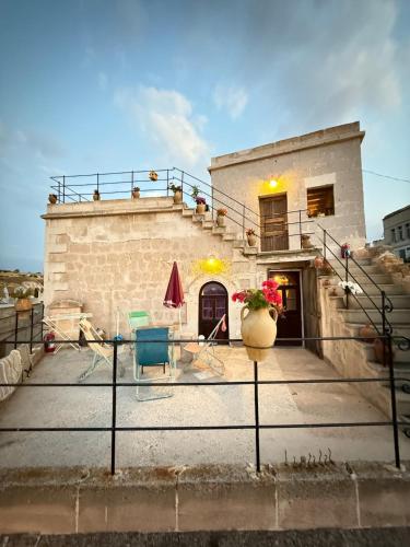 a building with a patio with a table and chairs at Katre Cave House in Ürgüp