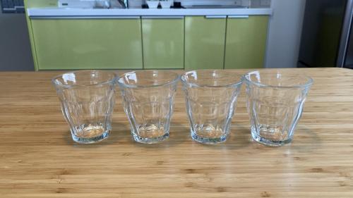 four empty glasses sitting on top of a wooden table at WALLABY HOUSE - Vacation STAY 38653v in Kawaguchi