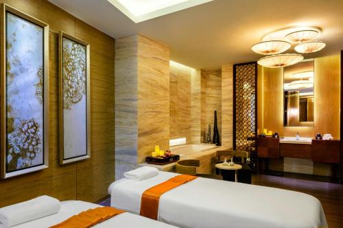 a hotel room with two beds and a bathroom at Sheraton Huzhou Taihu Lake Hot Spring Resort & Spa in Huzhou