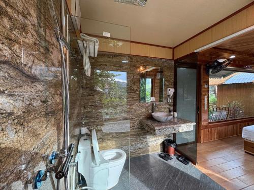 a bathroom with a shower and a toilet and a sink at Xuan Son Lakeside Bungalow in Ninh Binh