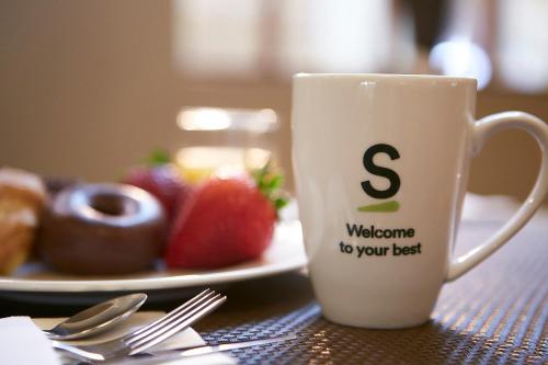 a coffee cup sitting on a table with a plate of food at Sercotel Toledo Imperial in Toledo