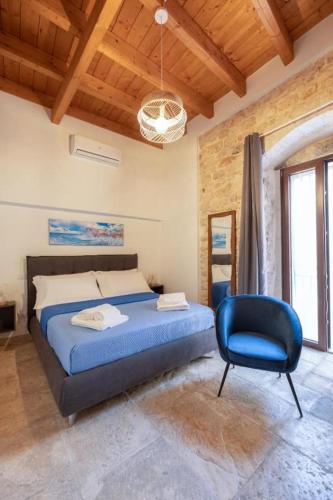 a bedroom with a bed and a blue chair at Palazzo Rizzi Dimora dei Templari in Bitetto
