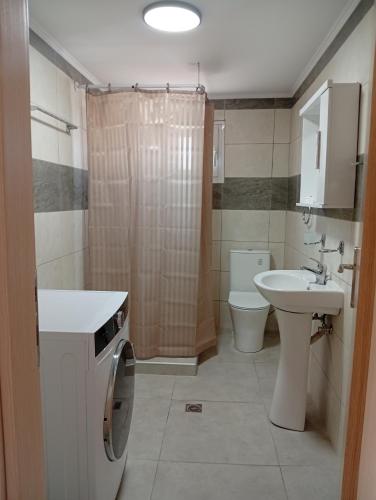 a bathroom with a sink and a washing machine in it at Tourni Cozy Chios in Chios