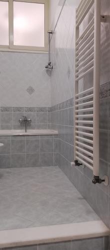 a bathroom with a sink and a tub and a window at Chloe's house in Agropoli